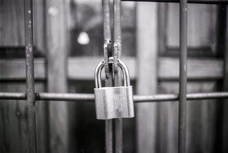 a padlock is attached to a metal gate.