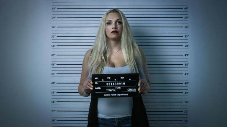 a woman holding a sign in front of a mug.
