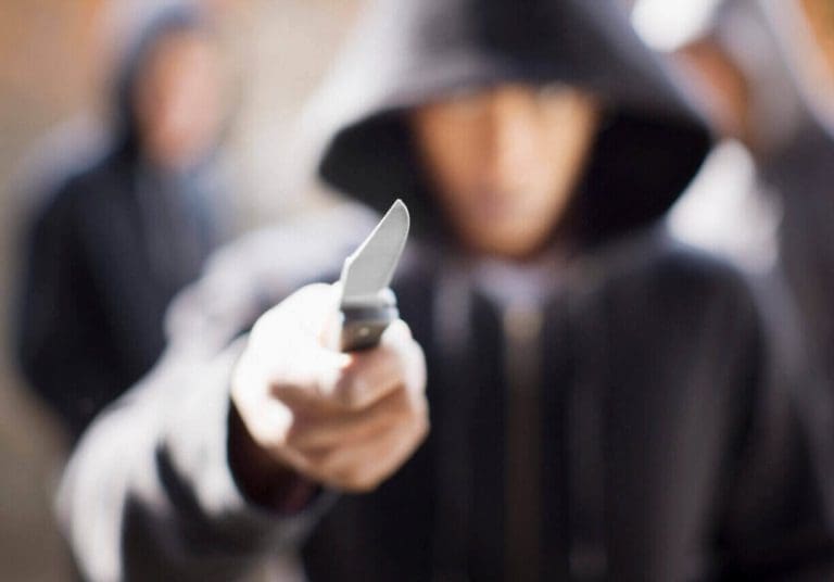 a person in a hooded jacket holding a knife.