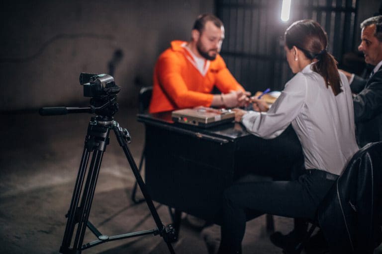 a man and a woman sitting at a table in front of a camera.