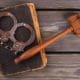 a judge's gaven and a pair of handcuffs on top of a book.