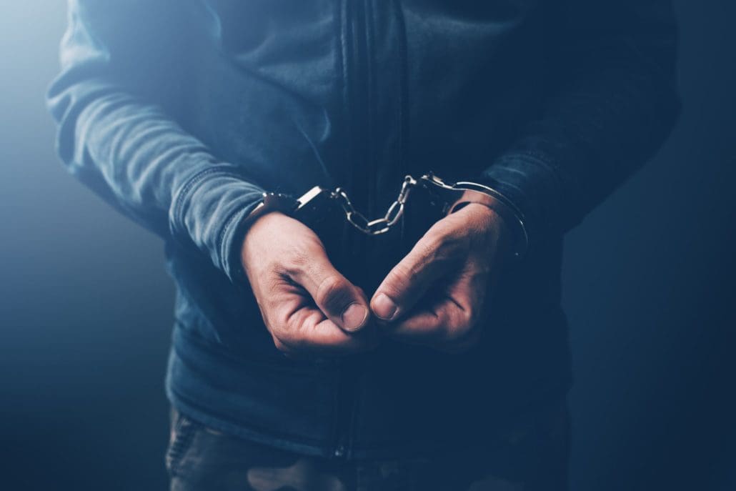 A man is holding his hands in handcuffs.