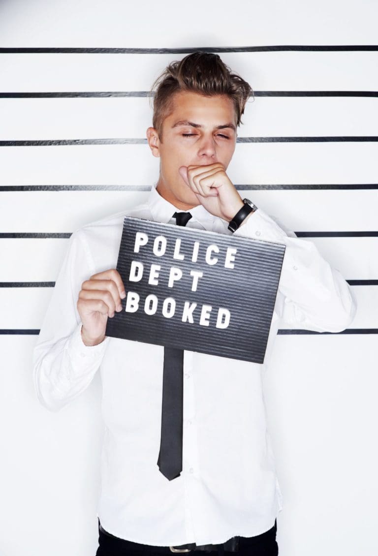 a man holding a sign that says police dept booked.
