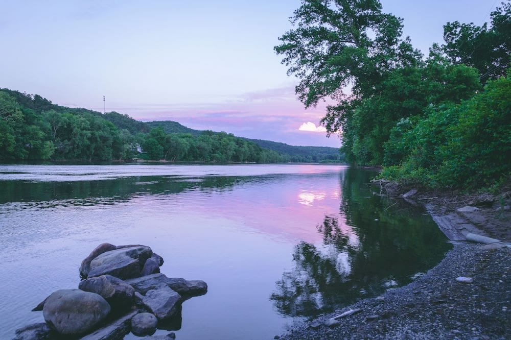 a body of water surrounded by trees and rocks.