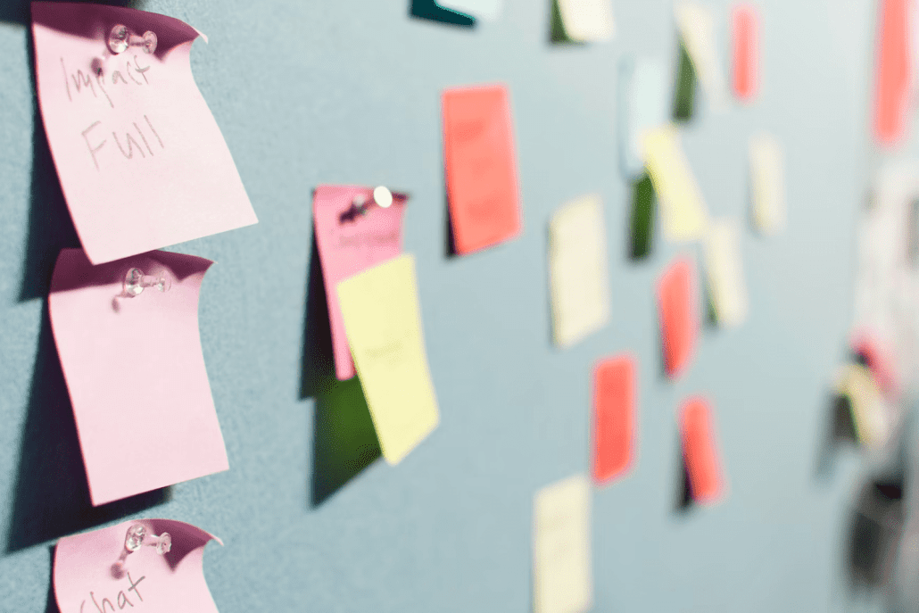 a bulletin board with sticky notes attached to it.