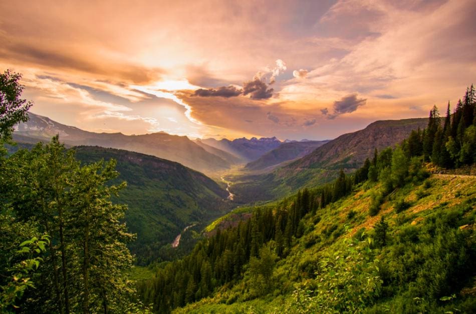 The sun is setting over a valley in the Montana mountains.