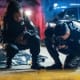 Two police officers kneeling next to a body at night.