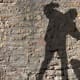 The silhouette of a man on a brick wall.