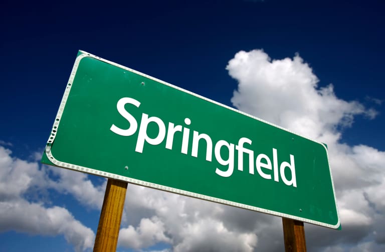 A green road sign with the word springfield on it.