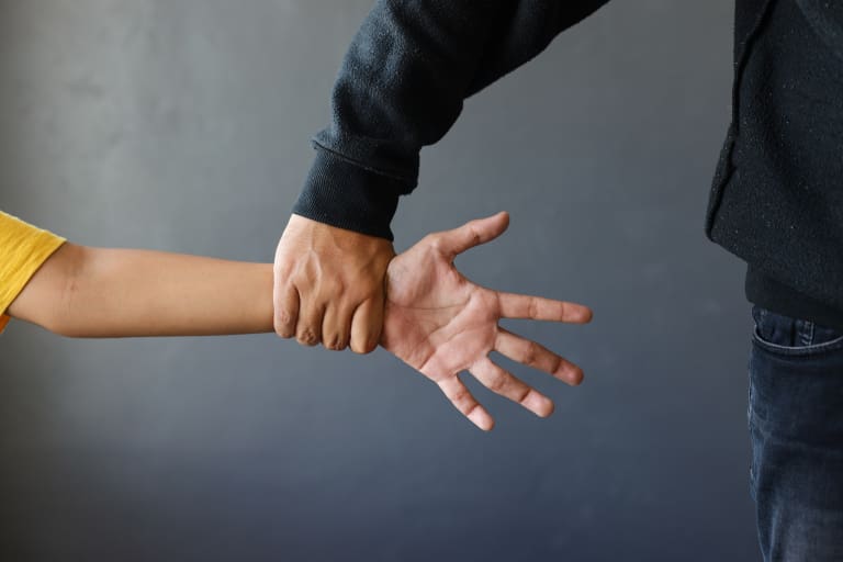 A man is holding a child's hand.