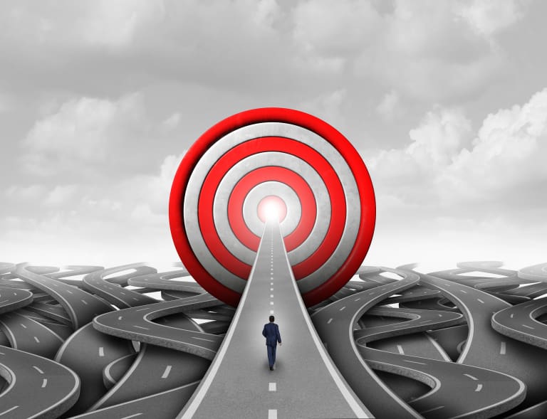 A businessman standing on a road with a target in the middle.
