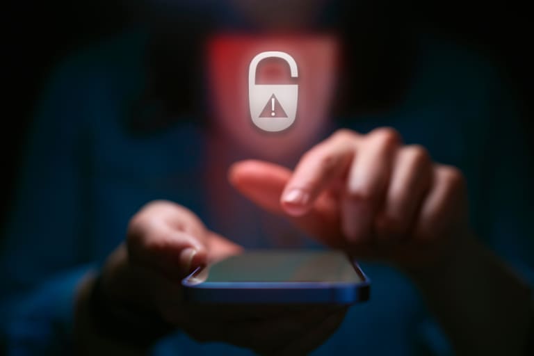 A person holding a smartphone with a padlock on it.