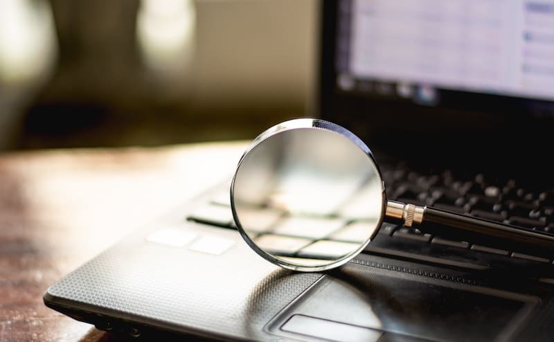 Magnifying glass is located on the keyboard. Of computer notebooks, Concept Disease analysis, consult various problems, study, online virus via internet or social.
